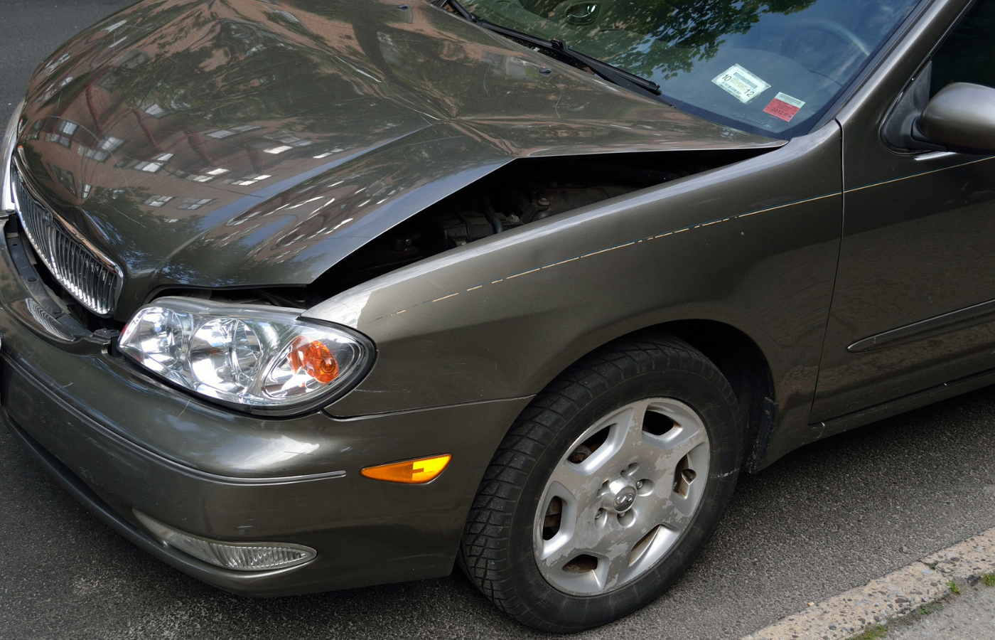 Image of a crashed car showing damage and dents with the hood bent in half in need of quality collision repair.